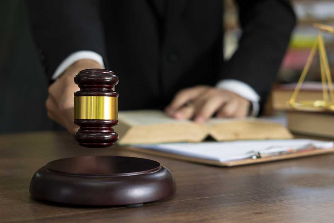 A picture of a judge holding a book and a gavel A picture of a judge holding a book and a gavel