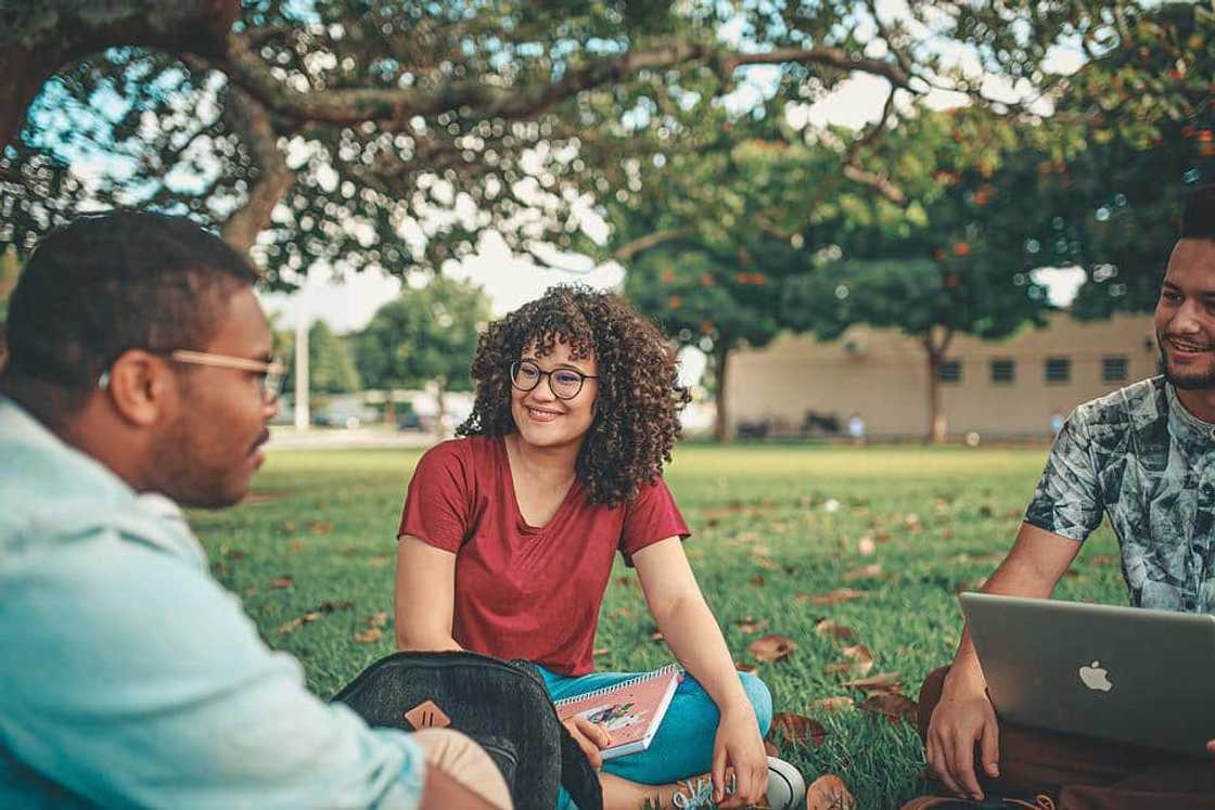 A group of students holding a discussion outdoors A group of students holding a discussion outdoors