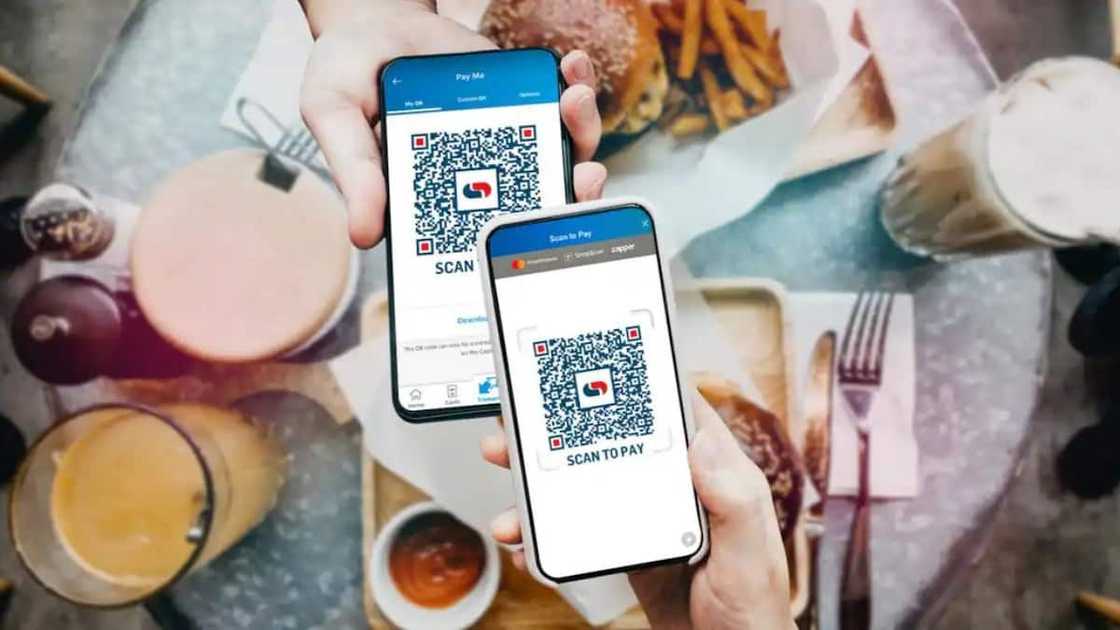 Two people holding phones with open Capitec app Two people holding phones with open Capitec app