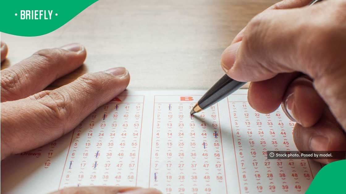 Close up of hands filling up a lottery ticket