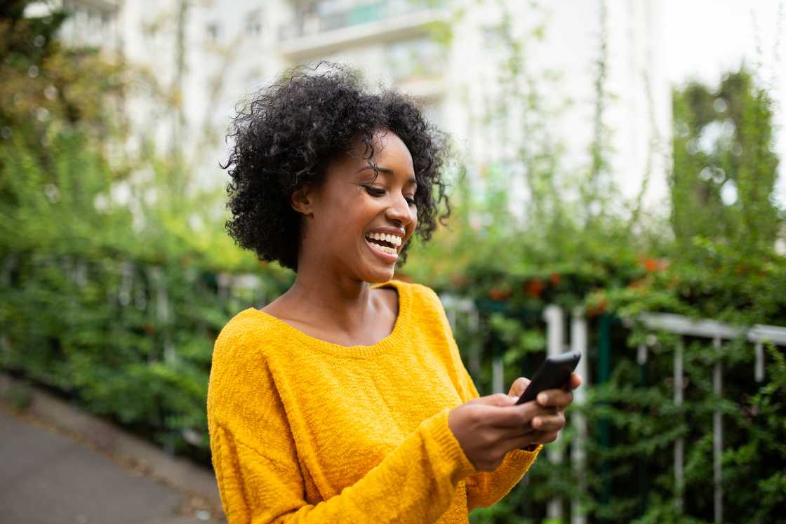 A woman smiling at her phone. A woman smiling at her phone.