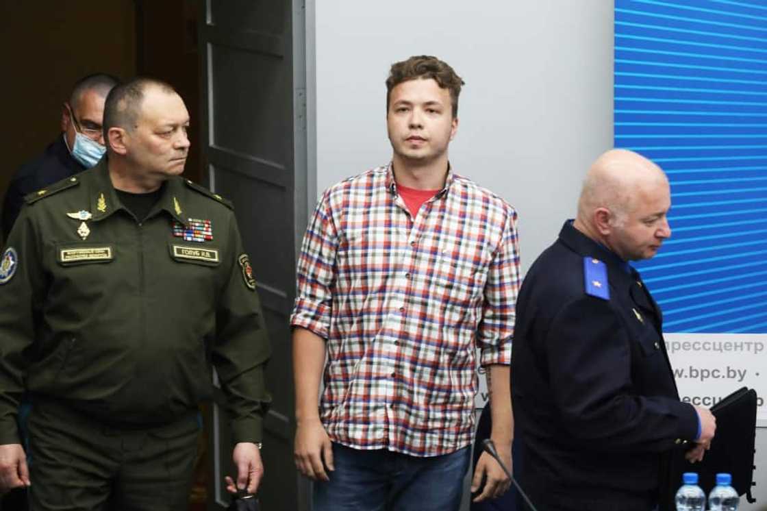 Chief of the Belarus Air Force  Igor Golub (L), Belarusian activist Roman Protasevich (C) and Chairman of the Investigative Committee of Belarus Dmitry Gora (R) enter a press center before a briefing for journalists and diplomats in Minsk on June 14, 2021