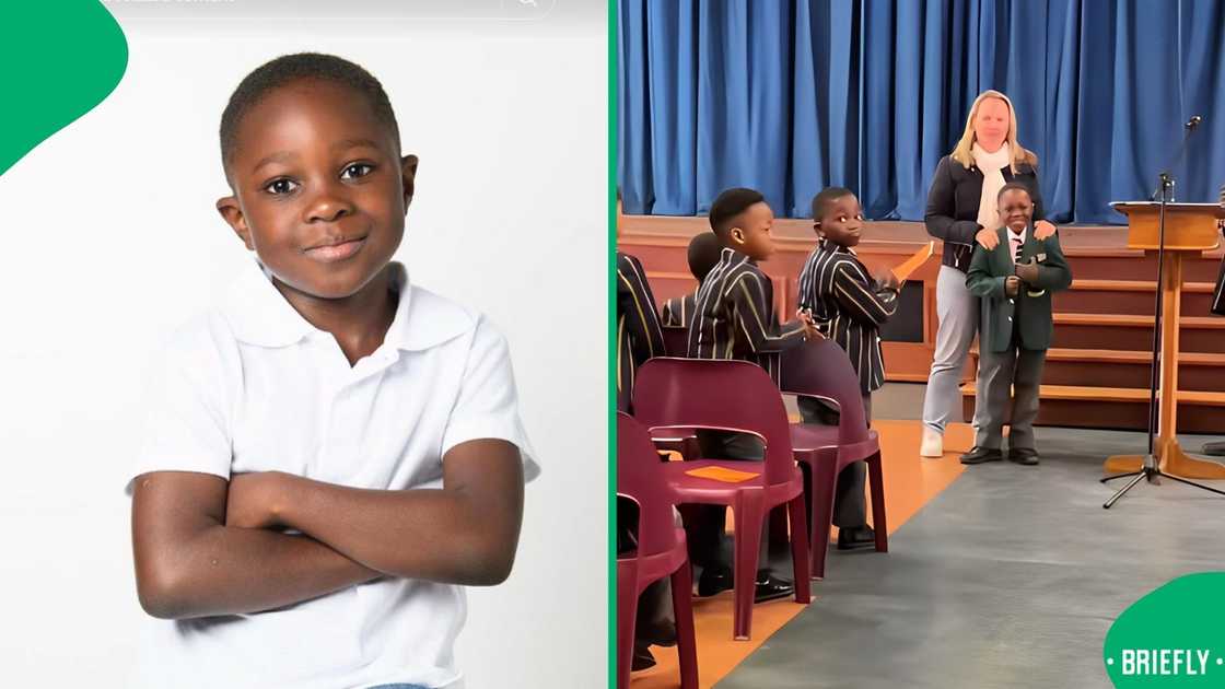 The little boy proudly stood in front of the school, full of boys cheering for him, as his mother put his green blazer on him