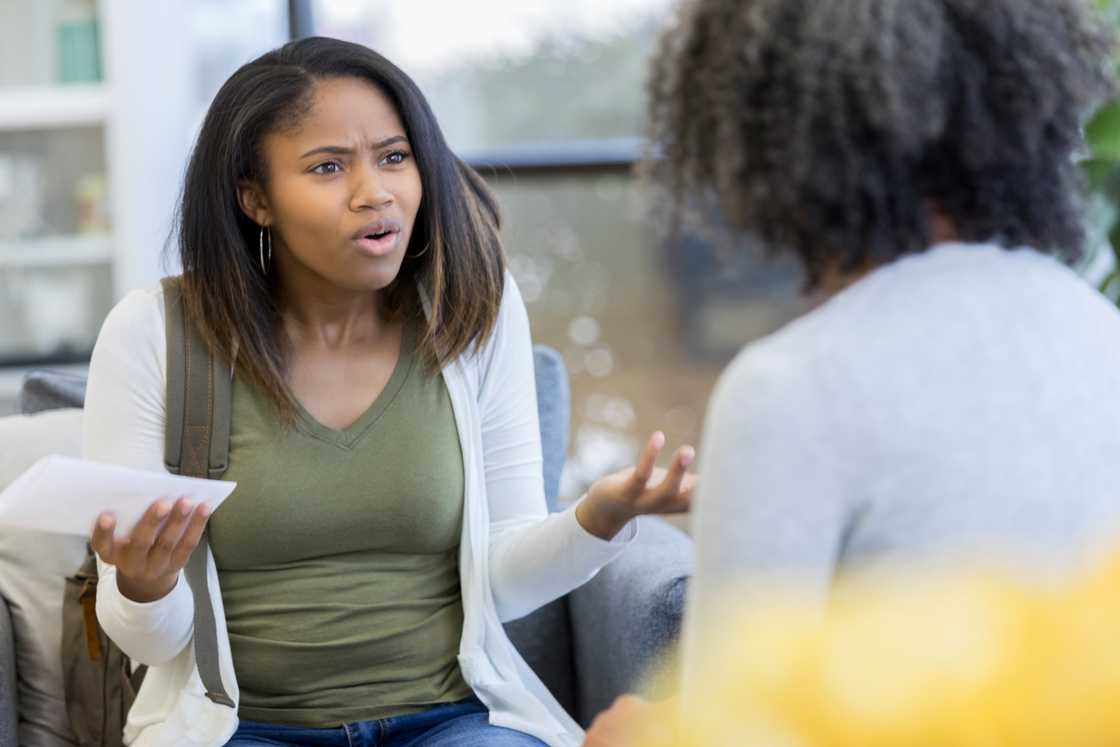 An angry young woman gestures while talking to a friend