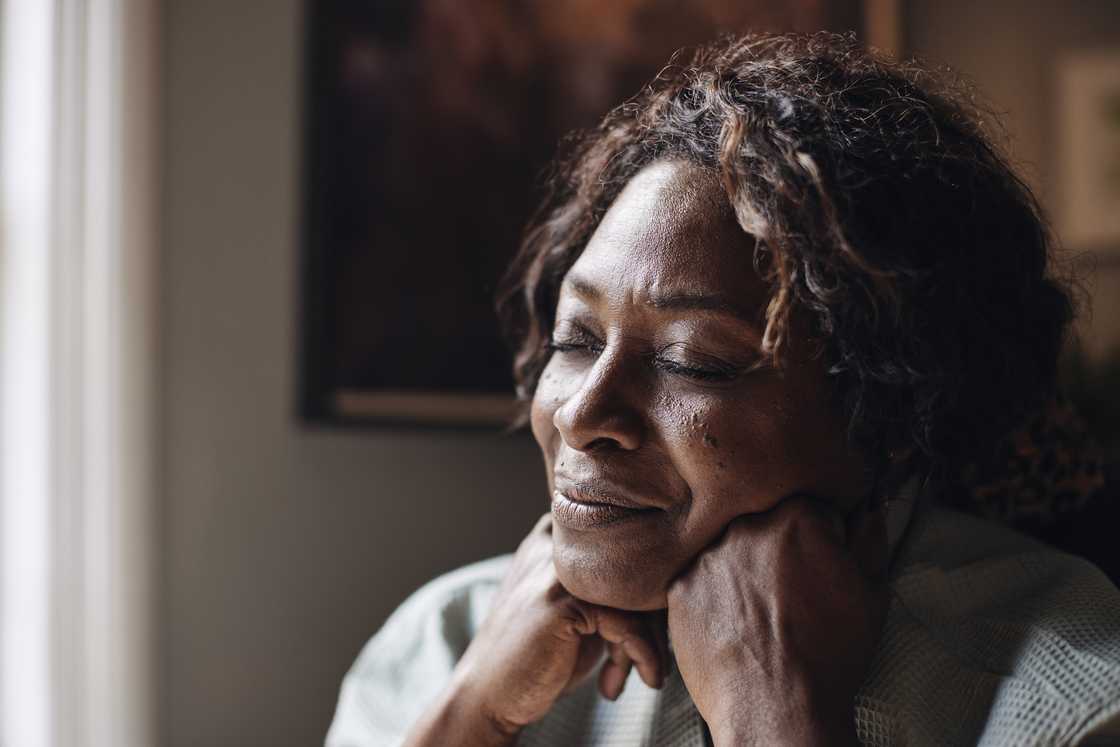 A tense woman sobbing and praying in a house
