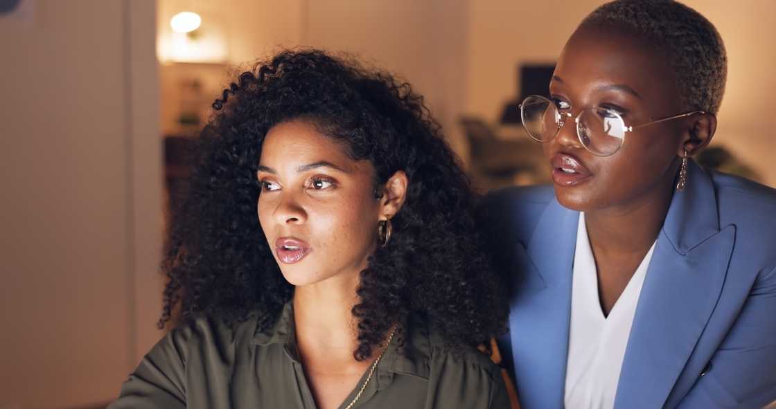 Two ladies in an office checking reports