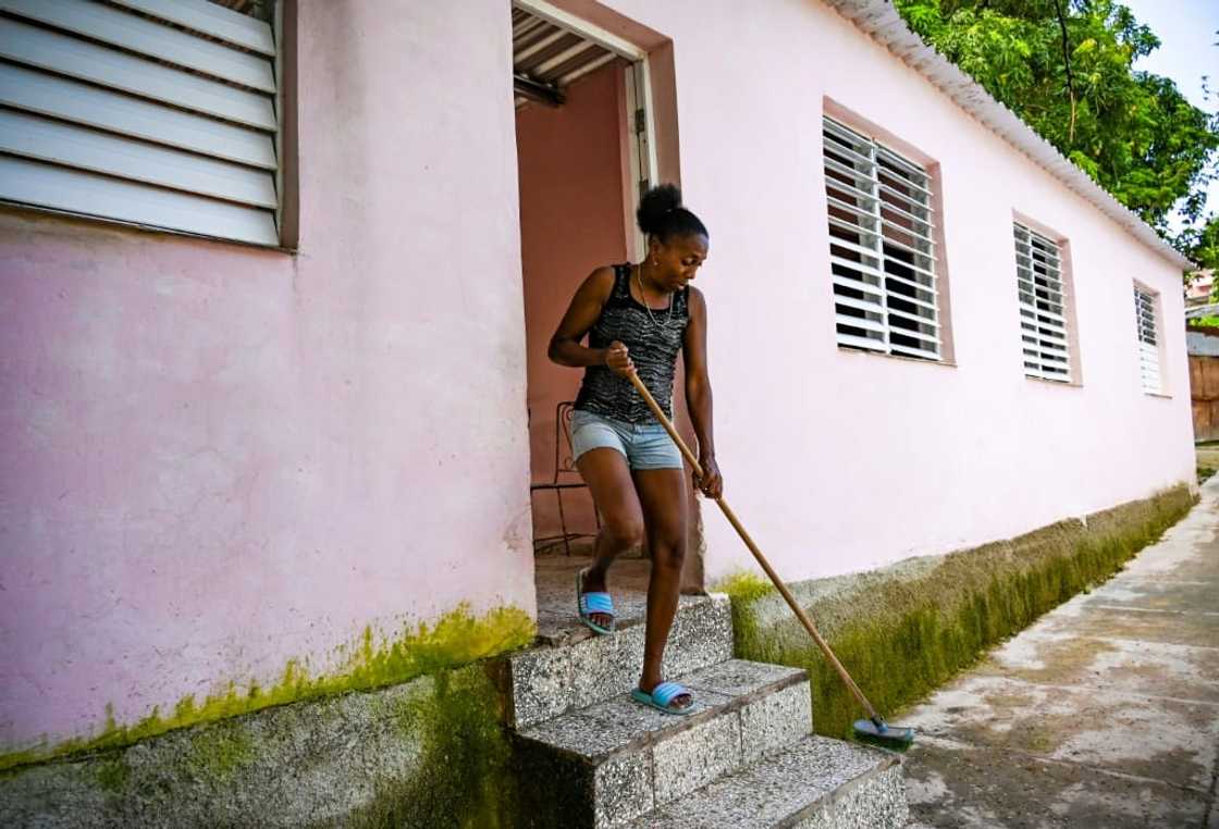 Isabel Hernandez, whose son was detained for taking part in anti-government protests, sweeps the stairs of her new house in Havana's La Guinera neighborhood in June 2022 Isabel Hernandez, whose son was detained for taking part in anti-government protests, sweeps the stairs of her new house in Havana's La Guinera neighborhood in June 2022