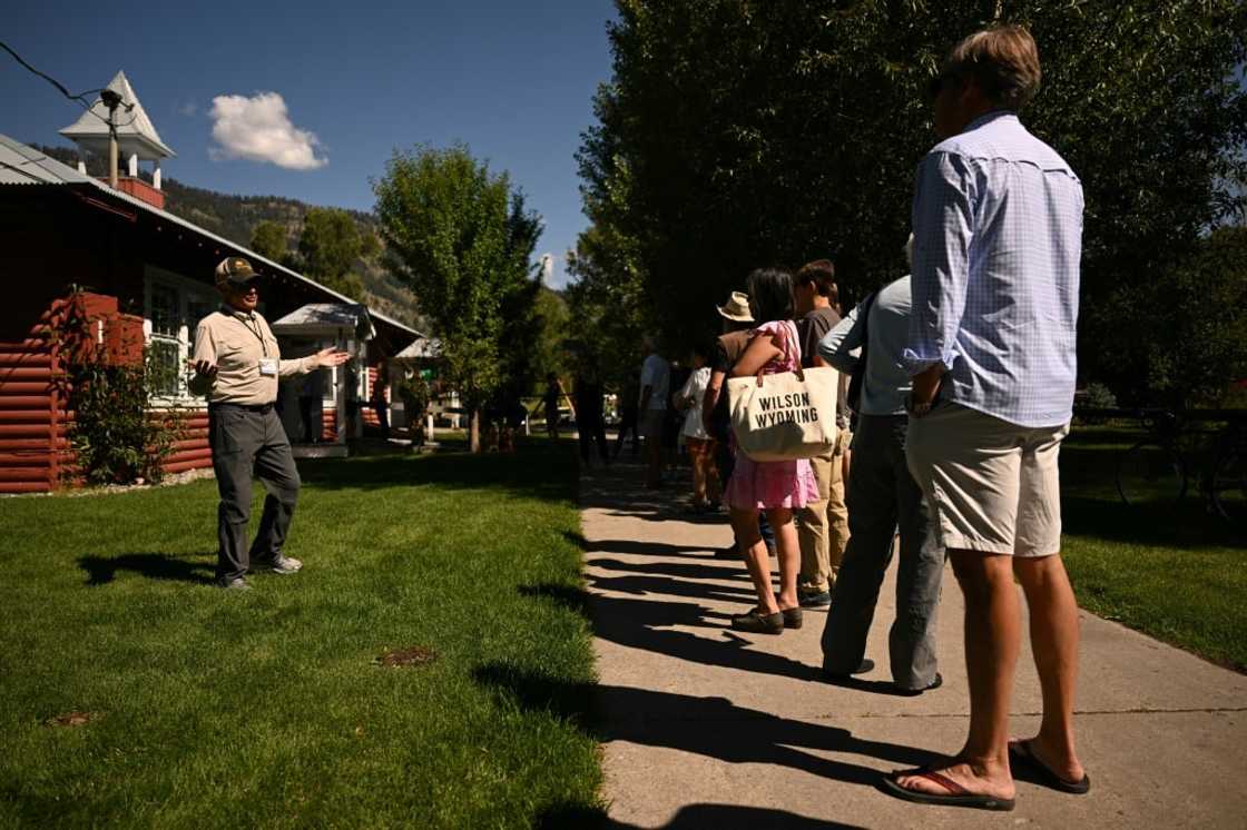 A poll worker speaks to people as they wait in line to vote in the Republican primary election at the Old Wilson Schoolhouse Community Center in Wilson, Wyoming, on August 16, 2022