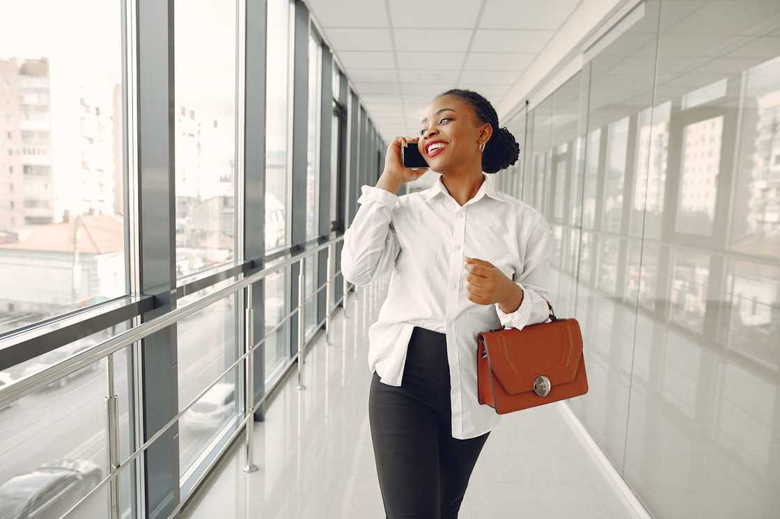 A woman walks confidently down a corridor of a modern building. A woman walks confidently down a corridor of a modern building.