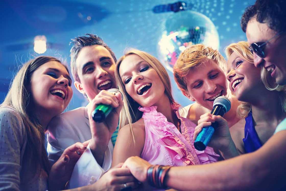 Friends singing karaoke at a disco themed sweet 16 birthday party. Friends singing karaoke at a disco themed sweet 16 birthday party.