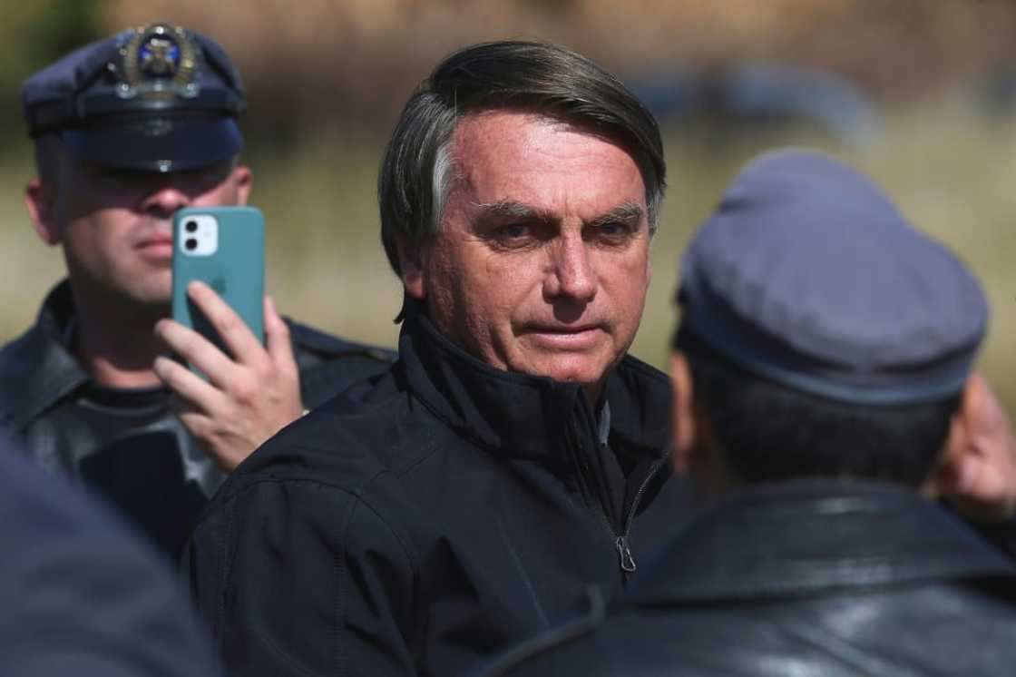 Brazil's President Jair Bolsonaro, seen here in May 2022, was caught on video grabbing a heckler by the shirt Brazil's President Jair Bolsonaro, seen here in May 2022, was caught on video grabbing a heckler by the shirt