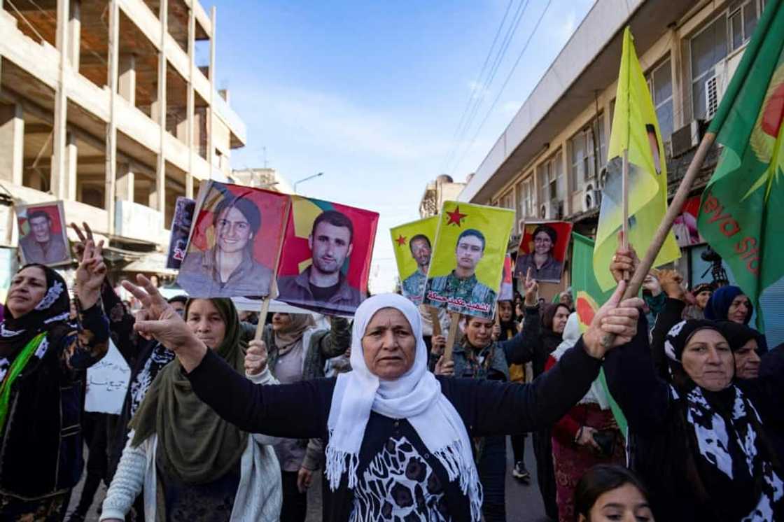 Syrian-Kurdish demonstrators in Qamishli raise pictures of people killed in Turkish strikes