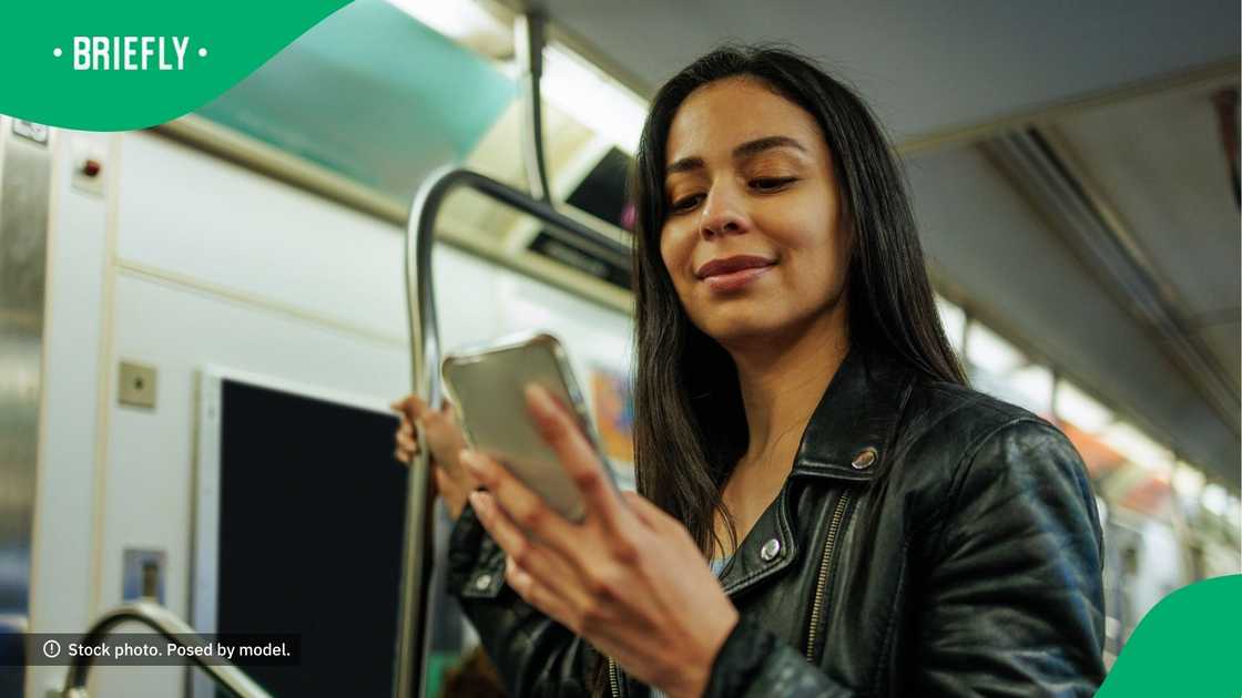 A woman smirking at her phone.