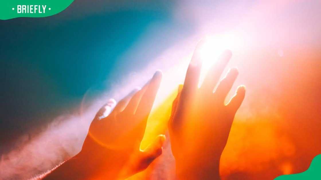 A pair of hands stretching out to the burning sun A pair of hands stretching out to the burning sun