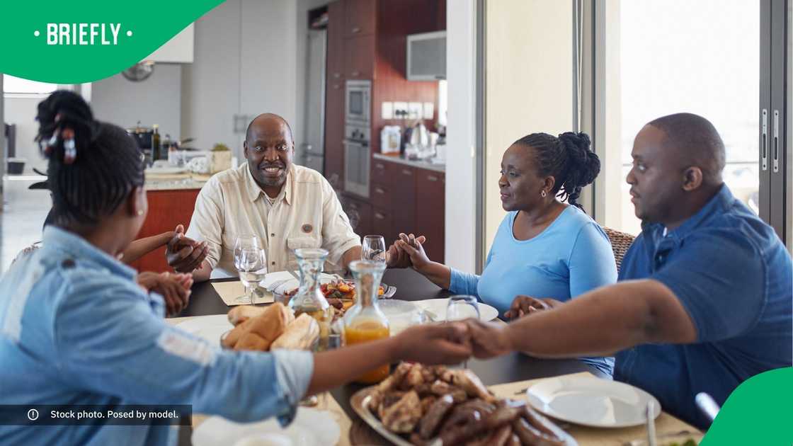 A family saying grace before eating their meal at home. A family saying grace before eating their meal at home.