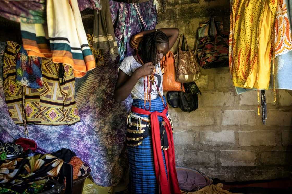 A young woman named Vicko prepares her outfit ahead of the ceremony to mark the end of the men's initiation period