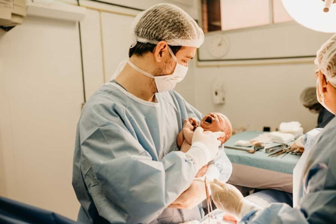 A medical personnel carrying a newly-born