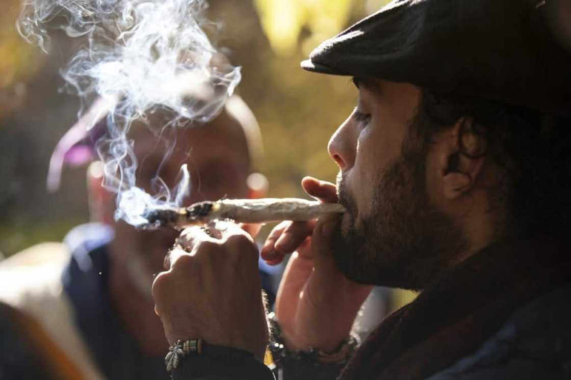 Canada has launched a review of its cannabis act, four years after legalizing its recreational use -- which was celebrated by thousands including this man pictured smoking a joint in Trinity Bellwoods Park in Toronto in October 2018