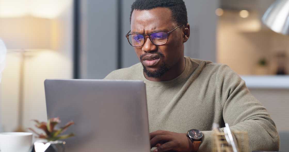 A shocked man staring at a laptop