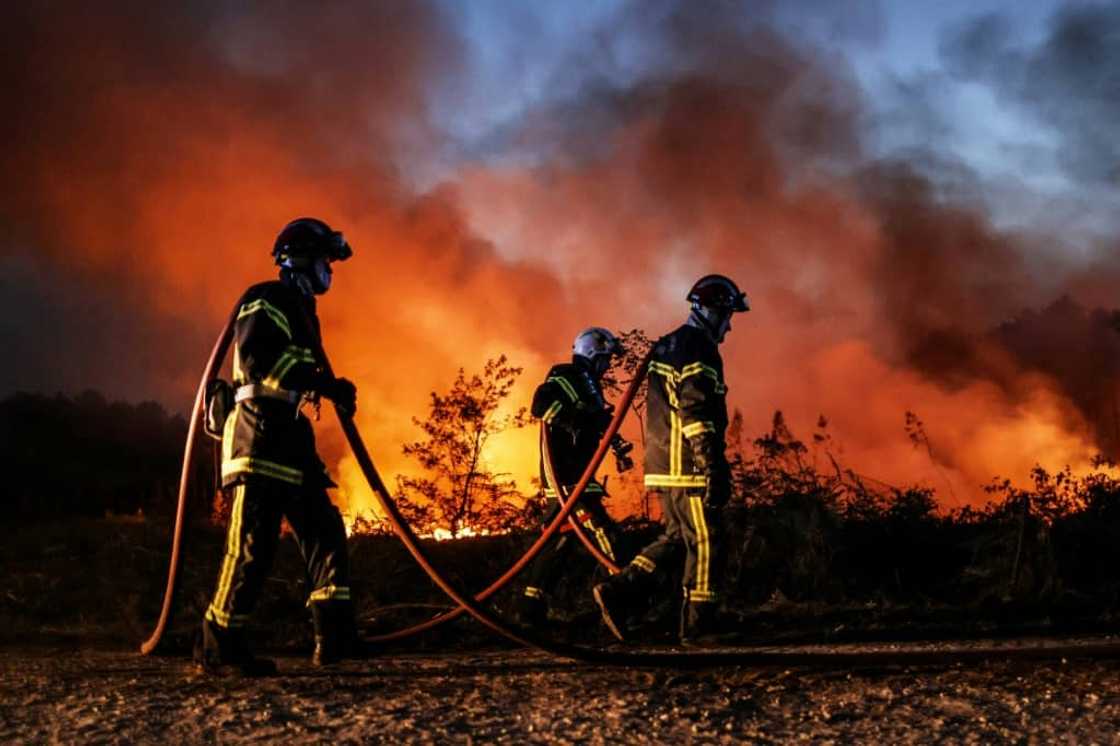 Firefighters try to control a separate fire further inland from the Dune de Pilat.