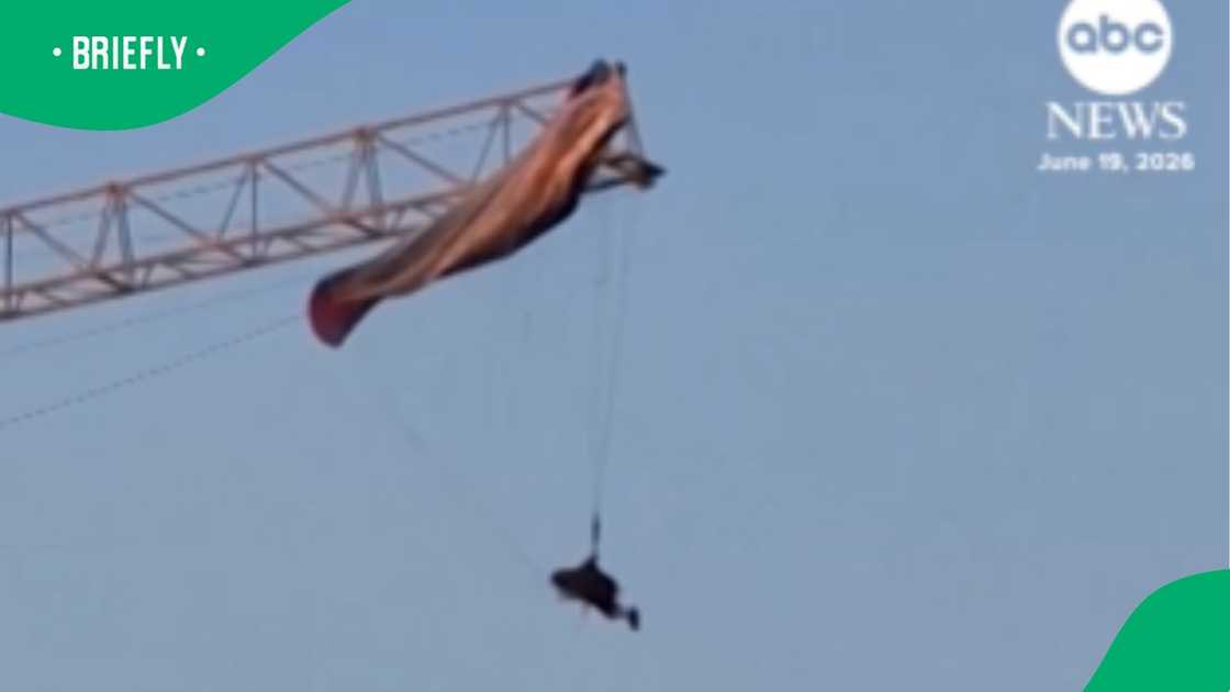 An ABC News video still captured a paraglider dangling helplessly in mid-air after their parachute became entangled on the metal frame of a high-rise construction crane during the day An ABC News video still captured a paraglider dangling helplessly in mid-air after their parachute became entangled on the metal frame of a high-rise construction crane during the day