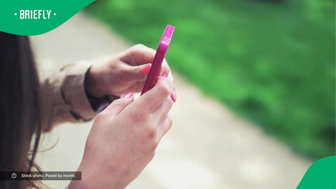 A woman typing on her phone. A woman typing on her phone.