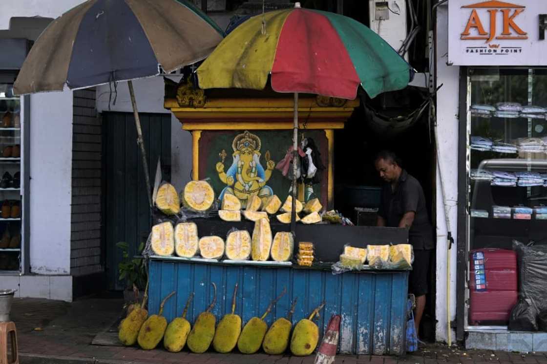 A vendor selling jackfruit waits for customers at a stall in Colombo in September