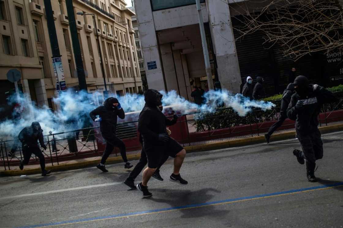 Protesters flee tear gas fired by Greek riot police in Athens Protesters flee tear gas fired by Greek riot police in Athens