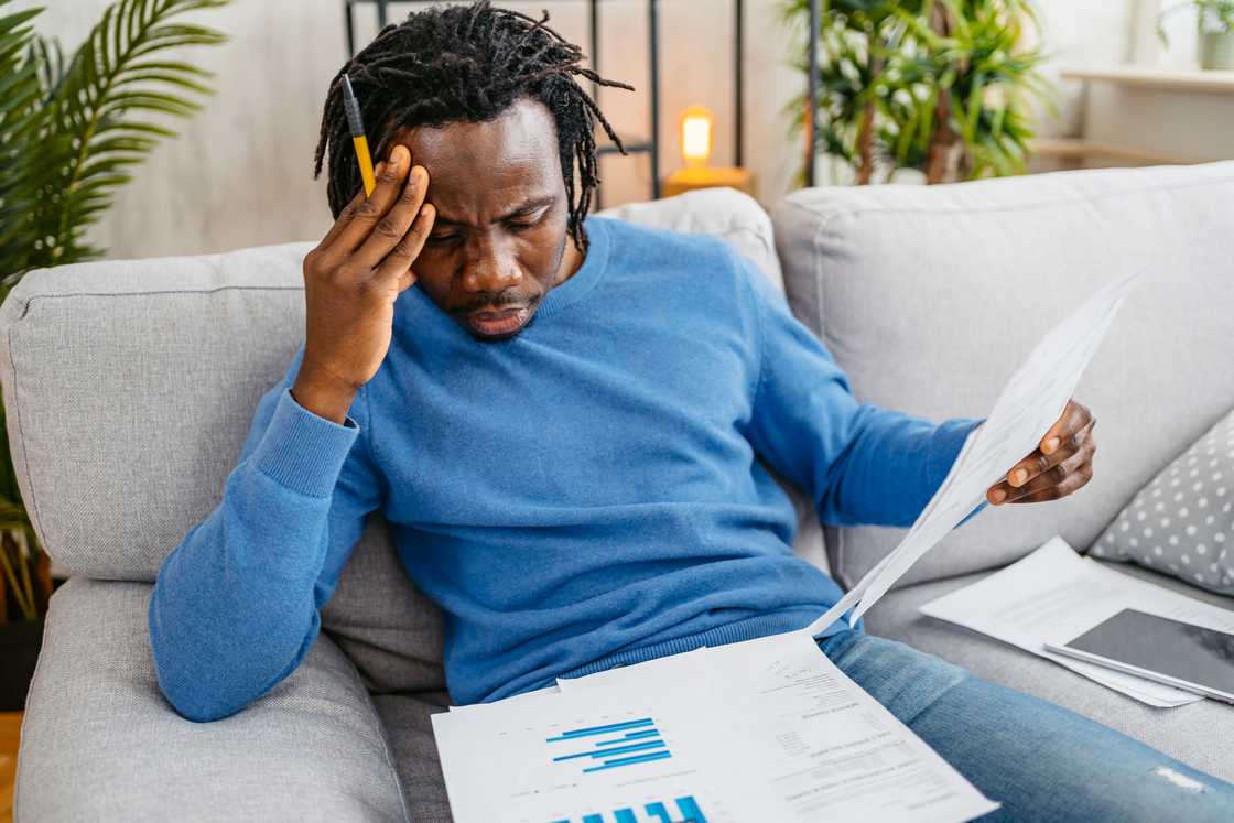 A stressed man going through his bills A stressed man going through his bills