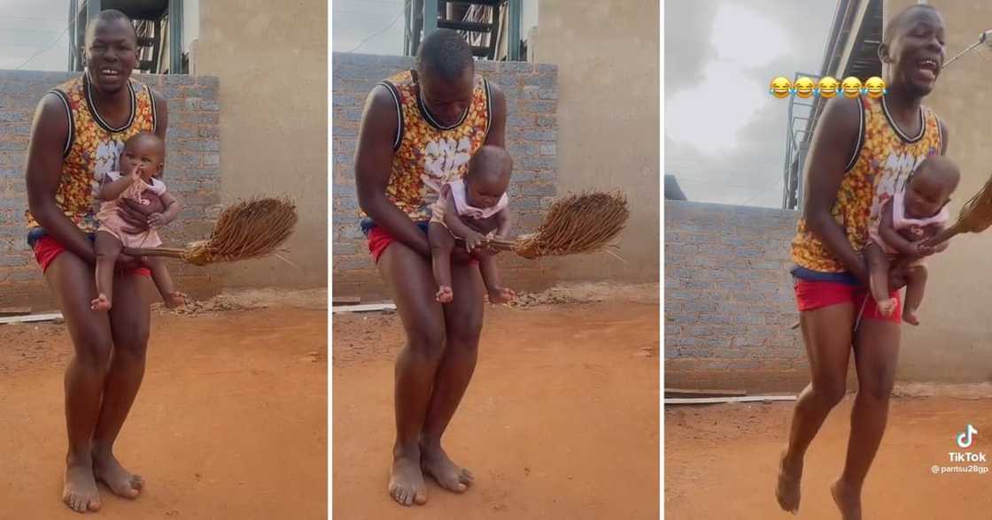 Limpopo man holding his daughter and a broom Limpopo man holding his daughter and a broom