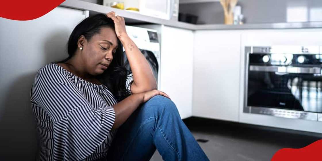 Photo of depressed mature woman sitting on the ground at home Photo of depressed mature woman sitting on the ground at home