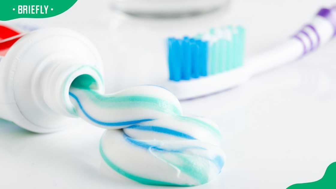 A tube of toothpaste and a glass on a white background A tube of toothpaste and a glass on a white background