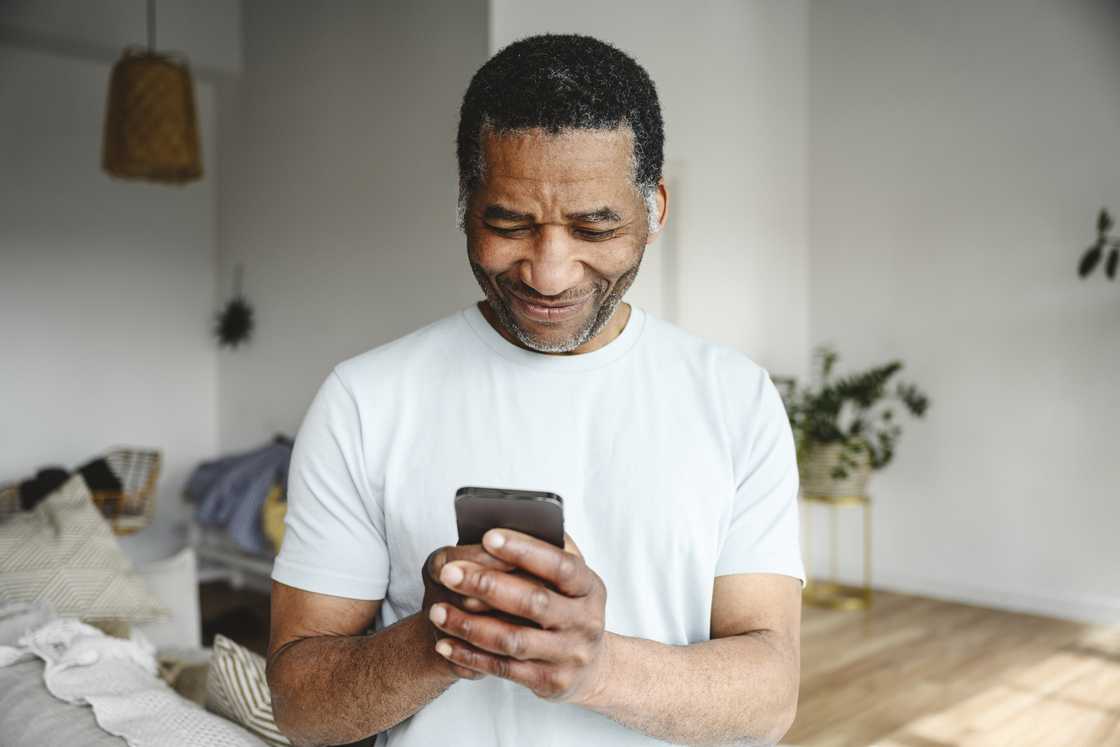 A man smiling at his phone.