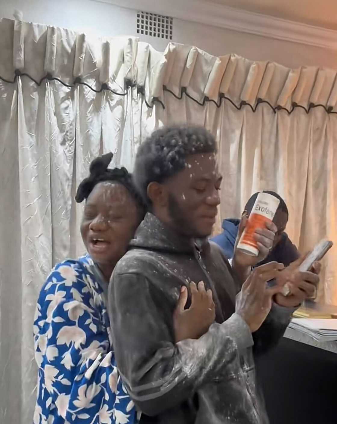 A Congolese mother hugged her son as she threw powder on him after he passed matric.