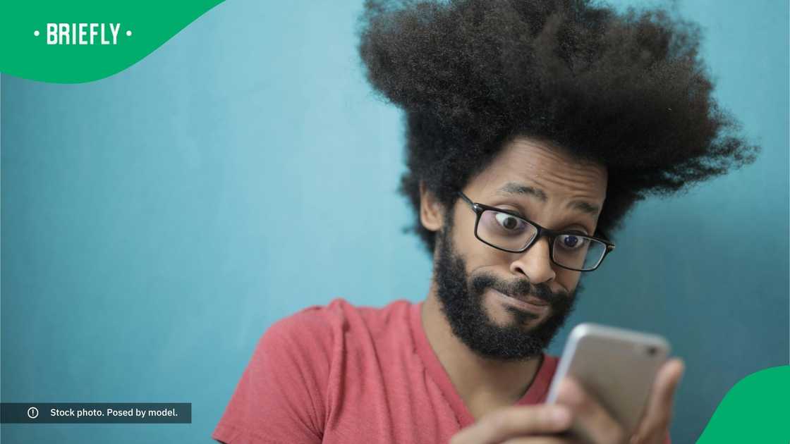 A surprised man looking at his phone.