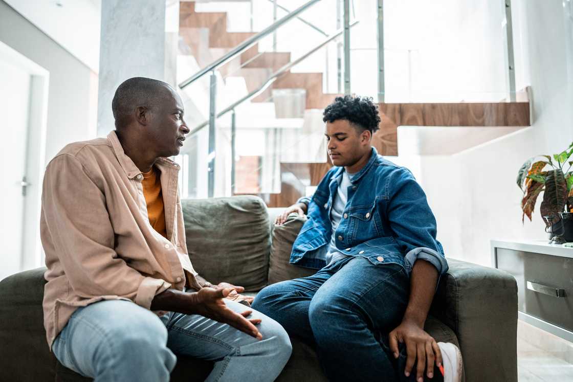 Two people sit on a couch in a modern, well-lit room. Two people sit on a couch in a modern, well-lit room.