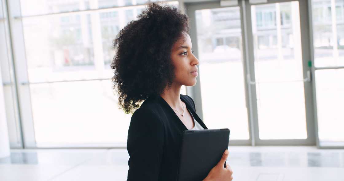 A woman with tablet walking with confidence
