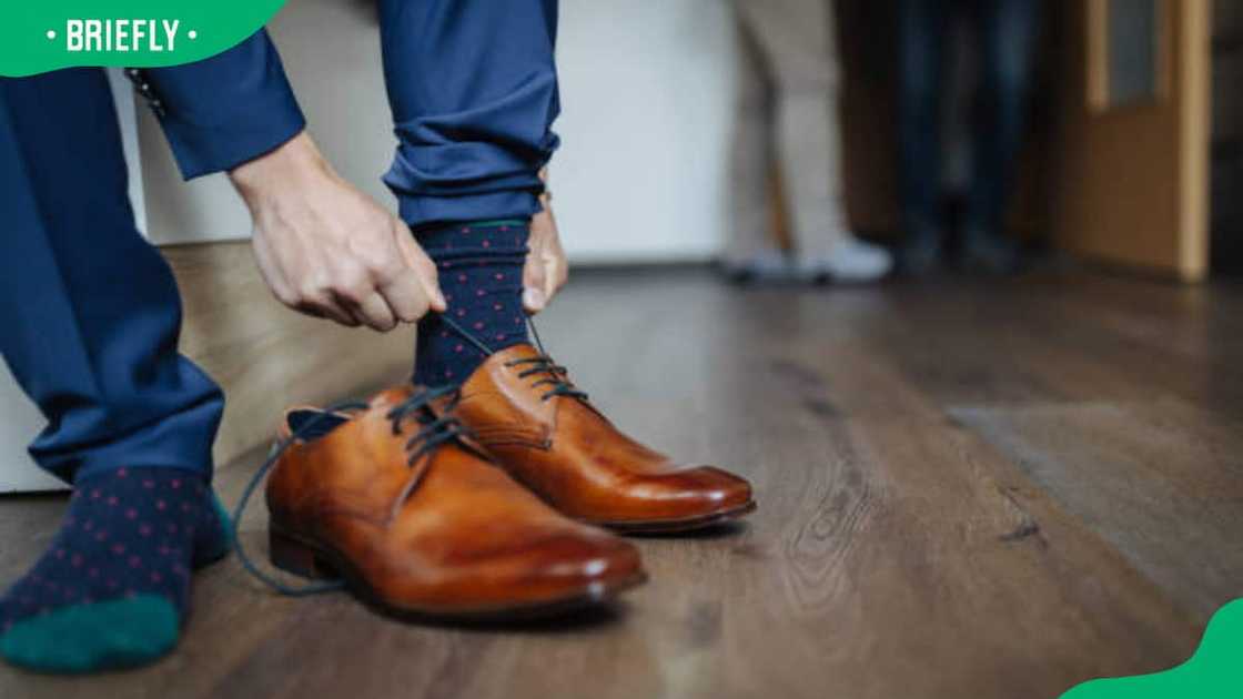 A man lacing his brown shoes