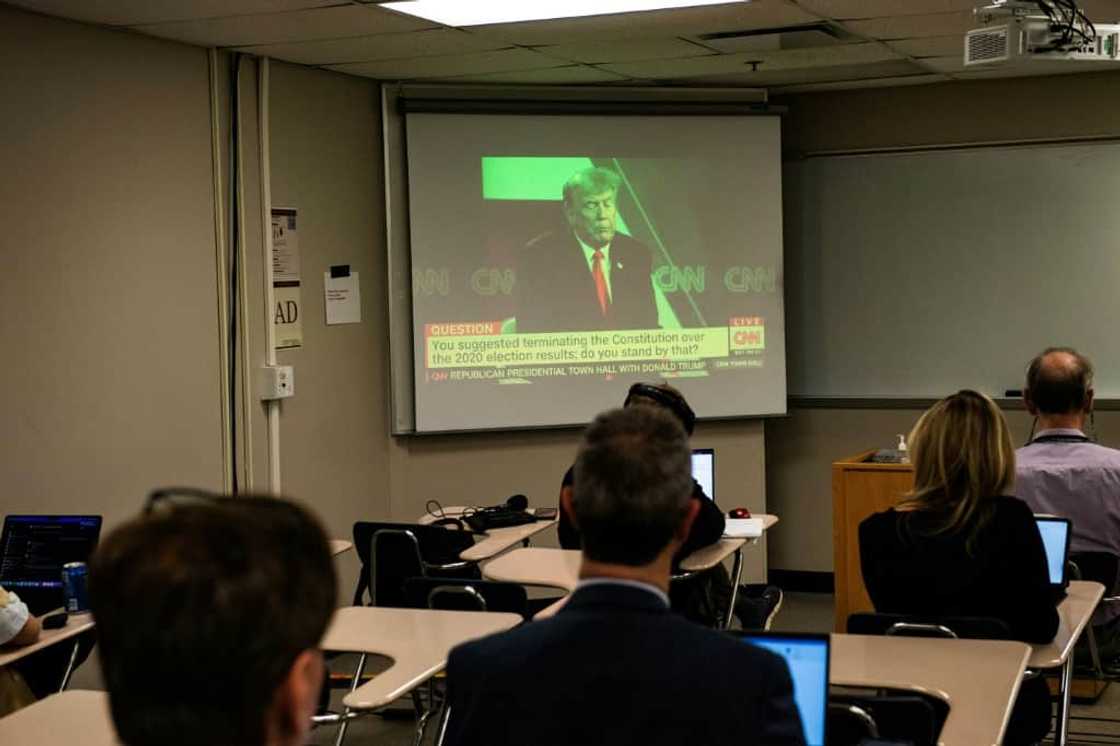 Reporters watch a CNN town hall with former US president and 2024 Republican hopeful Donald Trump at St. Anselm College in New Hampshire