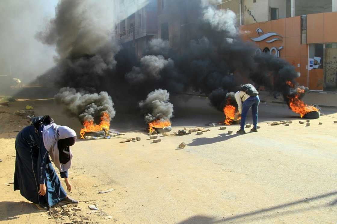 Tyres were set on fire by protesters angry at last year's military coup in Sudan to block roads in Khartoum