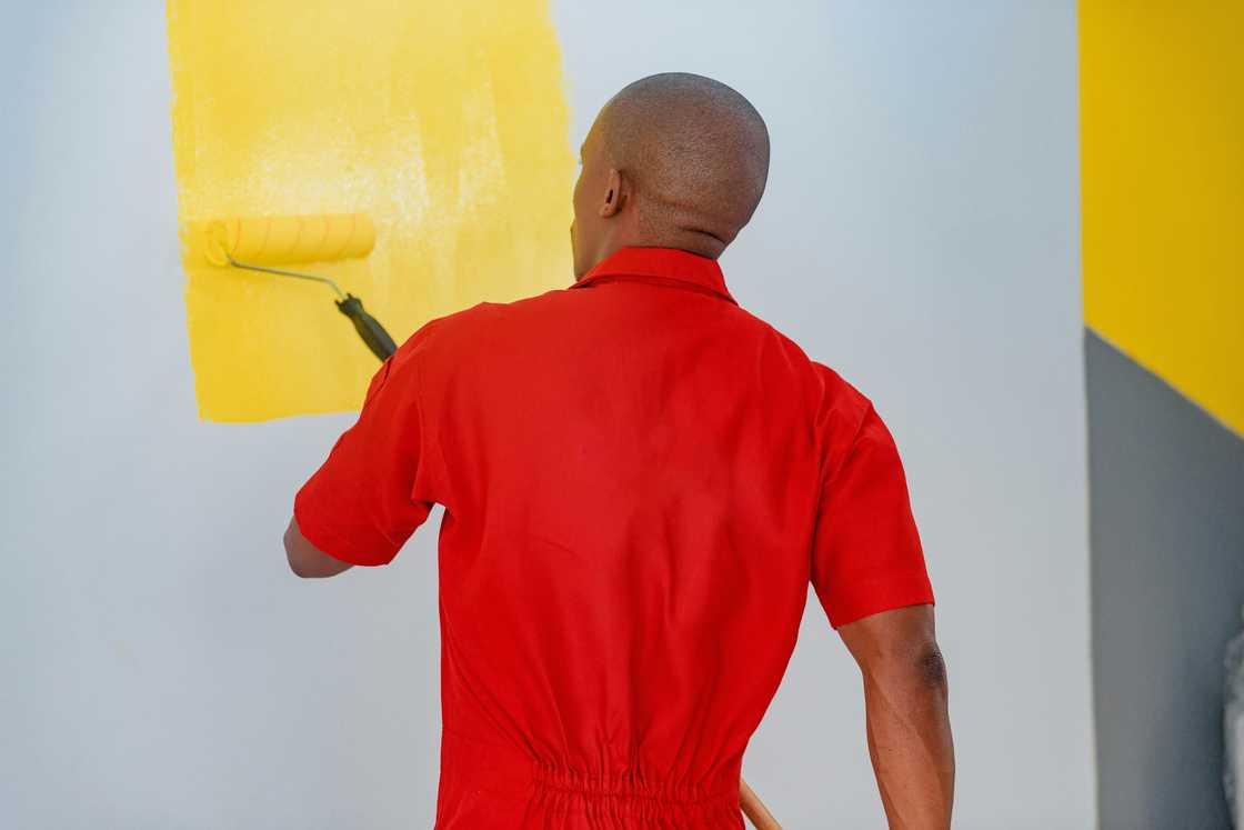 A man painting his house A man painting his house