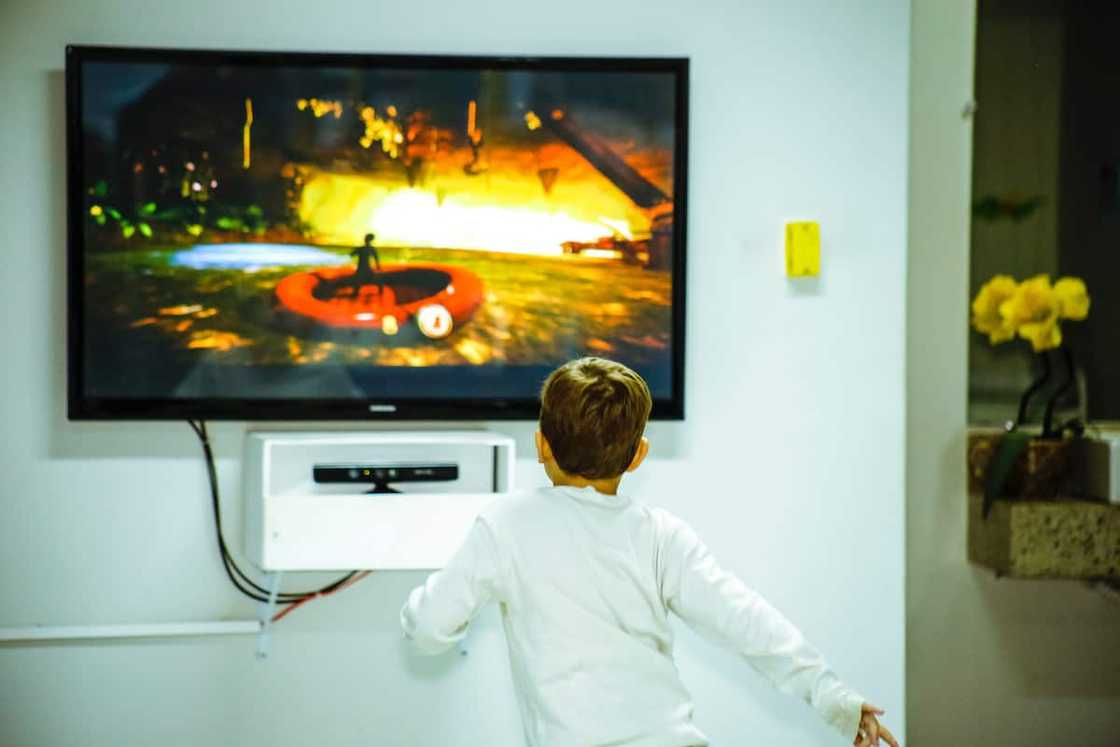 A young boy in front of a TV screen A young boy in front of a TV screen