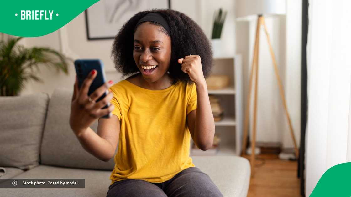 A woman smiling at her phone. A woman smiling at her phone.