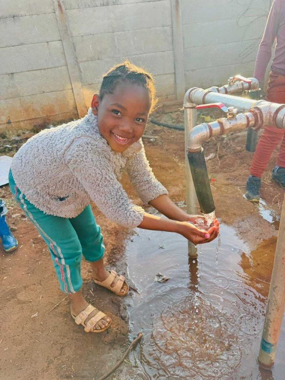 One of the children of Mabeskraal Village enjoying the water.