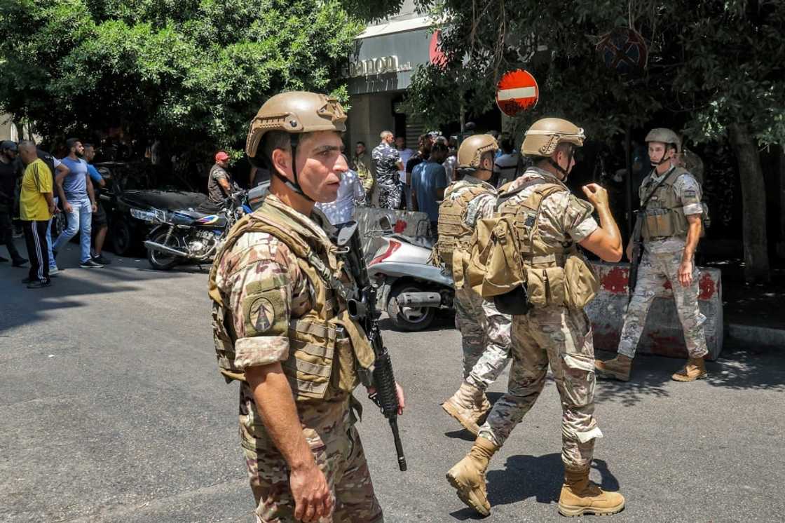 Lebanese army soldiers (front) and security forces (behind) gather outside a "Federal Bank" branch in Lebanon's capital Beirut where an armed customer was holding hostages Lebanese army soldiers (front) and security forces (behind) gather outside a "Federal Bank" branch in Lebanon's capital Beirut where an armed customer was holding hostages