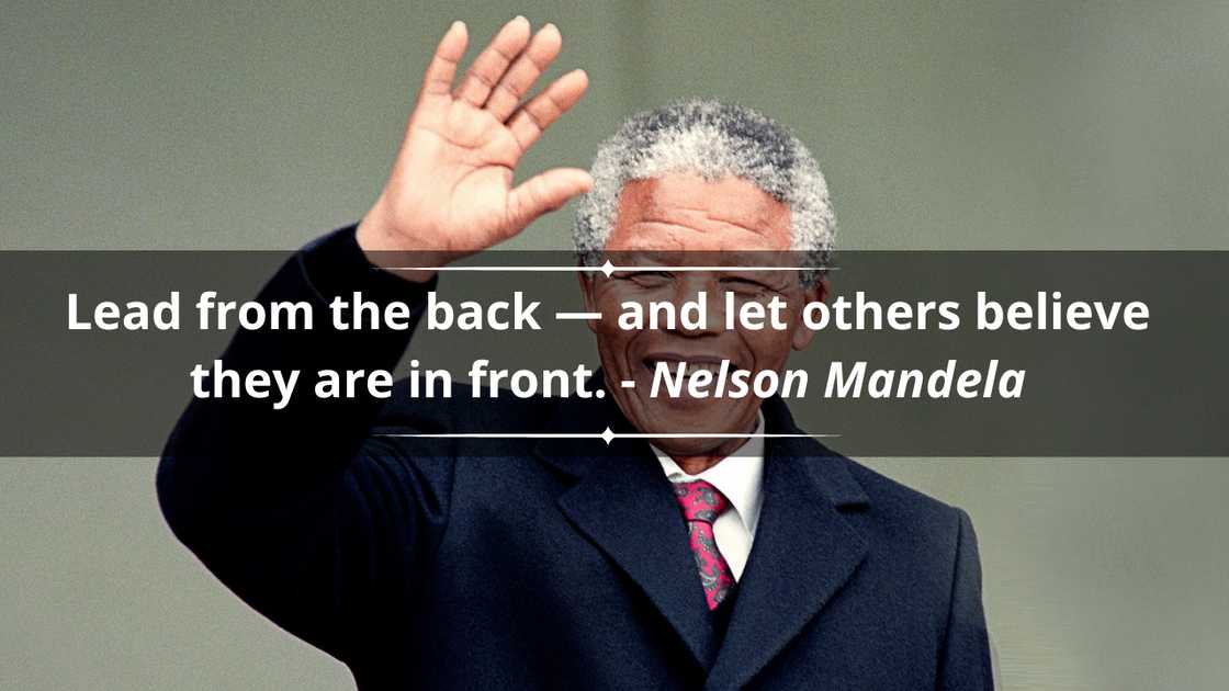The late Nelson Mandela is seen smiling in a black suit as he waves The late Nelson Mandela is seen smiling in a black suit as he waves