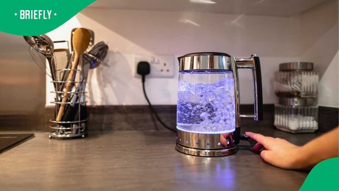A woman boiling a kettle of water.
