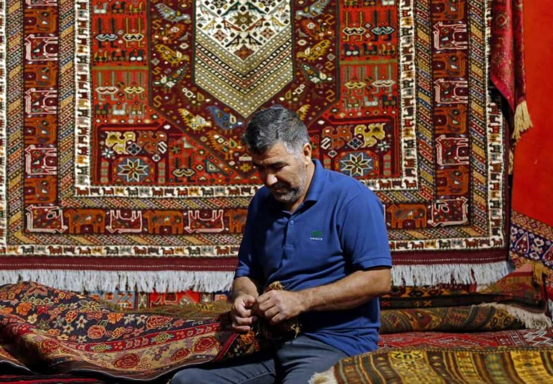 Rugs traditionally woven in the Islamic republic feature dense designs, often with curving floral patterns, in rich colours Rugs traditionally woven in the Islamic republic feature dense designs, often with curving floral patterns, in rich colours