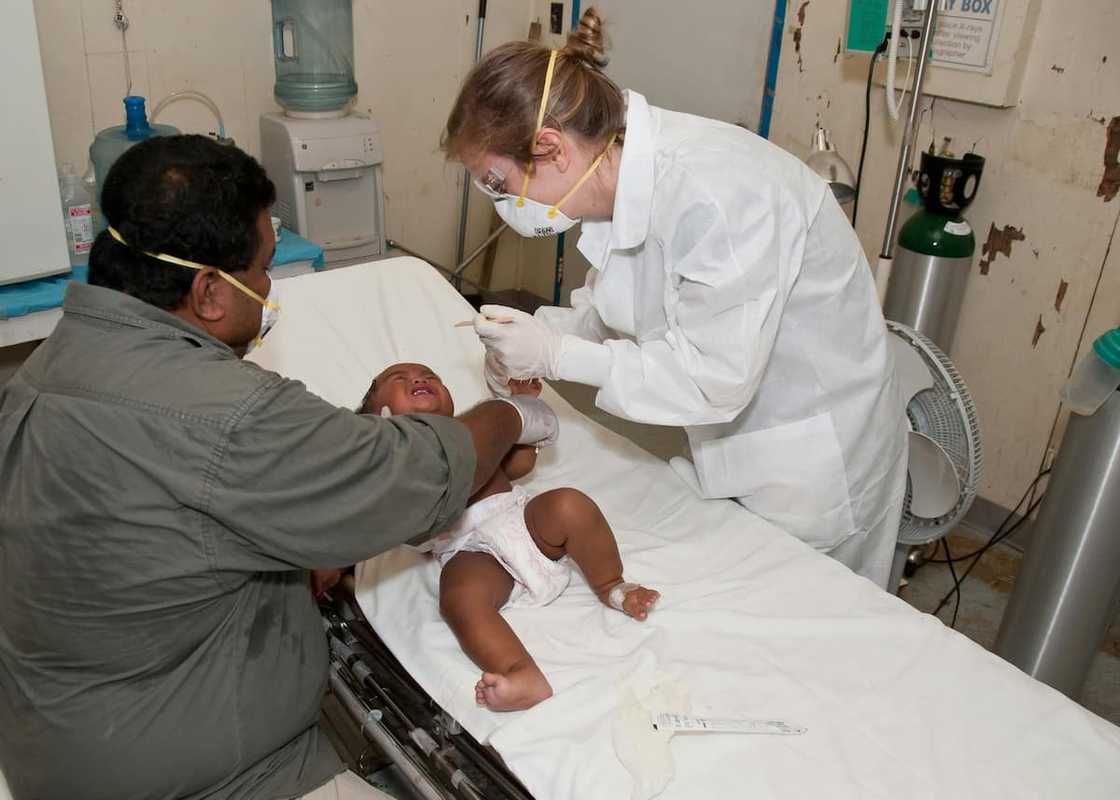 A medic doing a checkup on a small baby A medic doing a checkup on a small baby