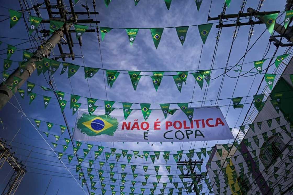 With Brazil's incumbent President Jair Bolsonaro adopting the colors of the flag as his own, Julio Cesar Freitas felt compelled to add a clarification to his family's green and yellow street decorations: 'It's not politics, it's the World Cup' With Brazil's incumbent President Jair Bolsonaro adopting the colors of the flag as his own, Julio Cesar Freitas felt compelled to add a clarification to his family's green and yellow street decorations: 'It's not politics, it's the World Cup'